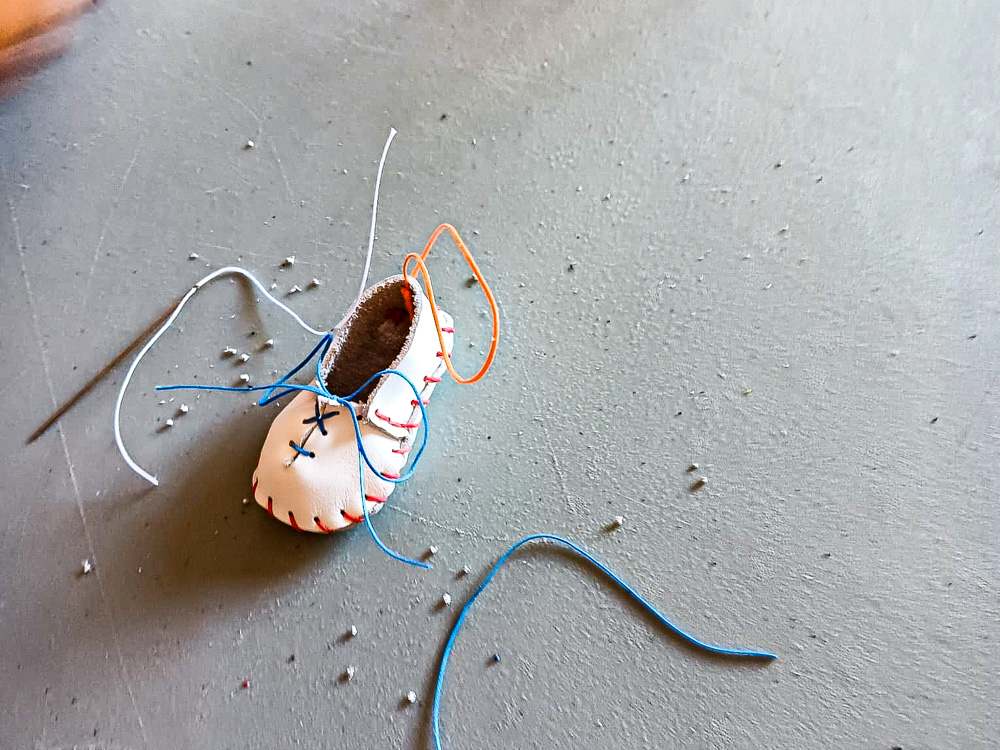 Mini-chaussures en cuir terminées, posées sur une table après un atelier manuel à Romans-sur-Isère