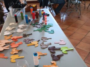 Outils et morceaux de cuir préparés pour un atelier de création de porte-clés chaussures, team building original en Drôme.